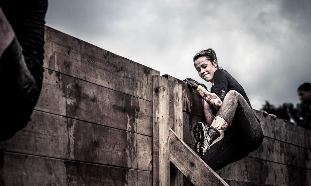 A person climbing a challenging assault course