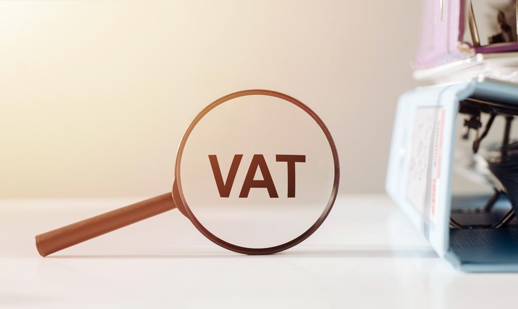 Magnifying glass with the word VAT on office table
